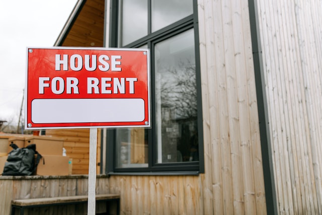 Red "House for Rent" sign in front of a residential property